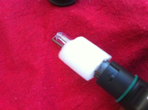 1990 Ford Bronco - A light bulb filament and socket are shown against a red background.