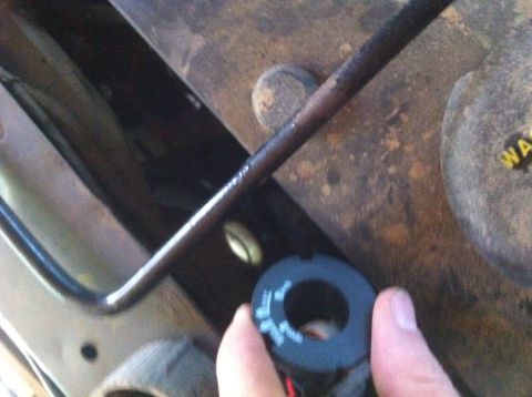 1990 Ford Bronco - Close-up of a vehicle's undercarriage, focusing on a hand holding a component.