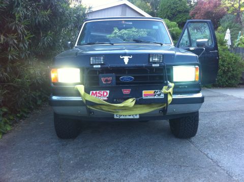 1990 Ford Bronco - This Ford truck features aftermarket lights and decals, including a bull emblem on the hood.