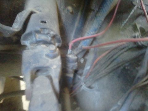 1979 Ford Bronco - This image shows a section of wiring and mechanical components within a vehicle's engine compartment.