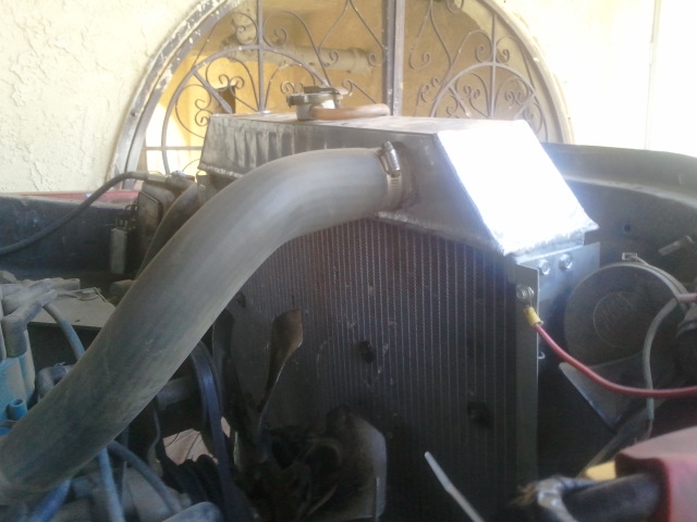 Engine bay detail showing a radiator, large hose, and fan