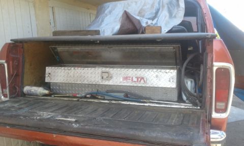 1979 Ford Bronco - Rear view of a 1979 Ford Bronco pickup truck bed, showing a Delta toolbox and various supplies.