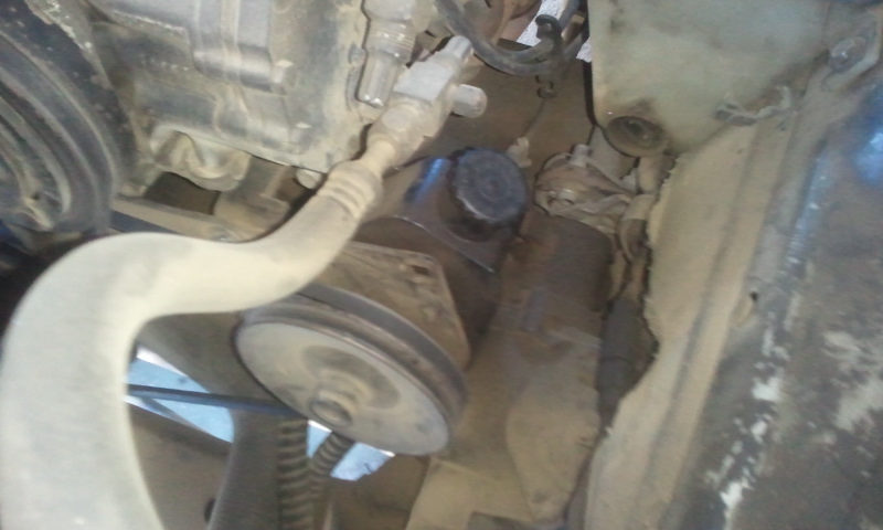 close-up of a pulley and hose assembly in an engine bay