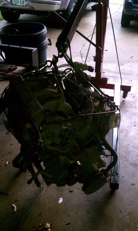 1994 Ford F-250 - Engine removed from a vehicle and suspended by an engine hoist.