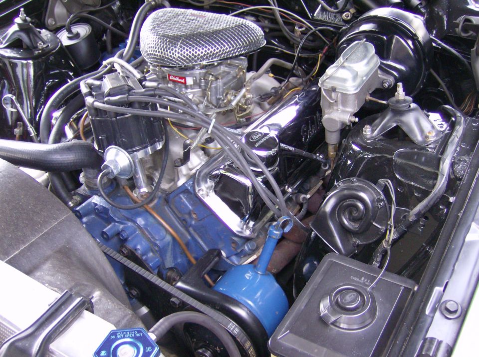 Engine bay of a 1970 Ford Ranchero, showing a V8 engine with chrome accents, a blue oil pan, and a chrome air cleaner