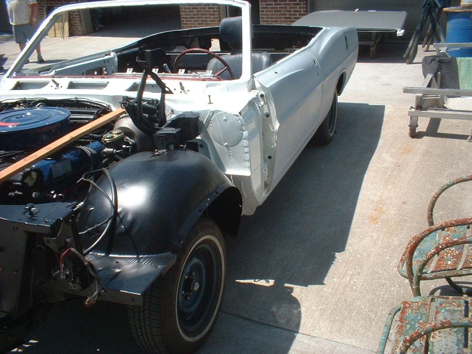 1967 Ford Galaxie convertible in white primer, front fender removed, engine exposed, viewed from the front-right