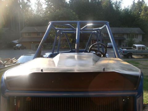 1979 Ford Bronco - Front view of a custom buggy's roll cage and hood, with a pickup truck visible in the background.
