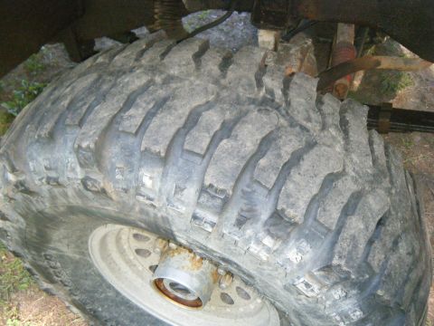 1990 Ford Bronco - A detailed view of a vehicle's tire and suspension system, with visible rust on the hub.
