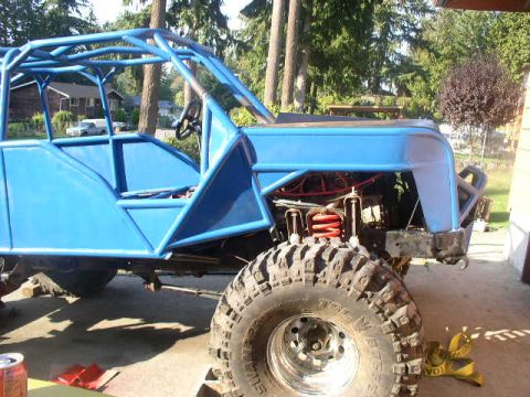 1979 Ford Bronco - A custom-built off-road buggy with a blue roll cage and body panels sits in a driveway.