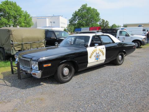 1991 Ford Crown Victoria - This 1977 Dodge Monaco police car features a black and white paint scheme with 'Highway Patrol' text on the doors.