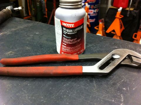 1987 Suzuki Samurai - A bottle of Loctite anti-seize lubricant and a pair of adjustable pliers are placed on a workbench.