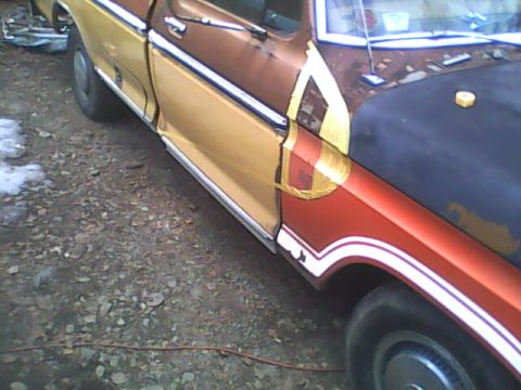 1976 Ford F-150 - A partially repainted Ford truck sits outdoors with visible tape on its body panels.