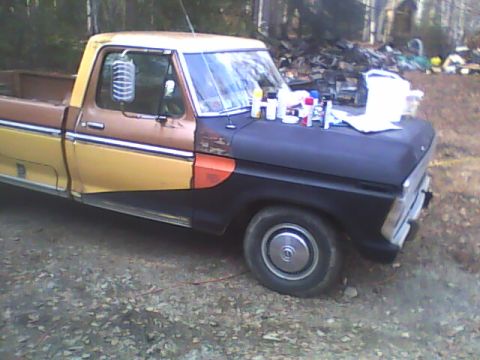1976 Ford F-150 - This 1976 Ford F-150 shows a multi-tone paint scheme with spray cans visible on the hood, suggesting ongoing work.
