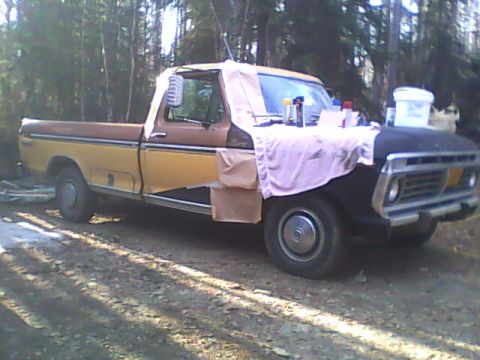 1976 Ford F-150 - This 1976 Ford F-150 pickup truck is parked outside, with its hood covered and appearing to be undergoing some work.