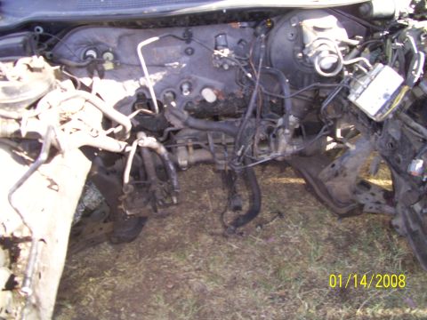 1995 Ford Probe - A dark colored car is parked outside, its details obscured by the lighting and angle.