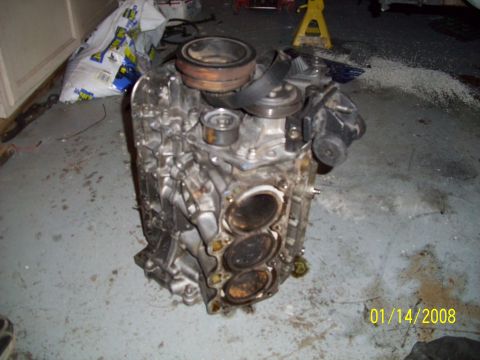 1995 Ford Probe - This engine block shows signs of wear and tear, with visible cylinder openings and metal components.