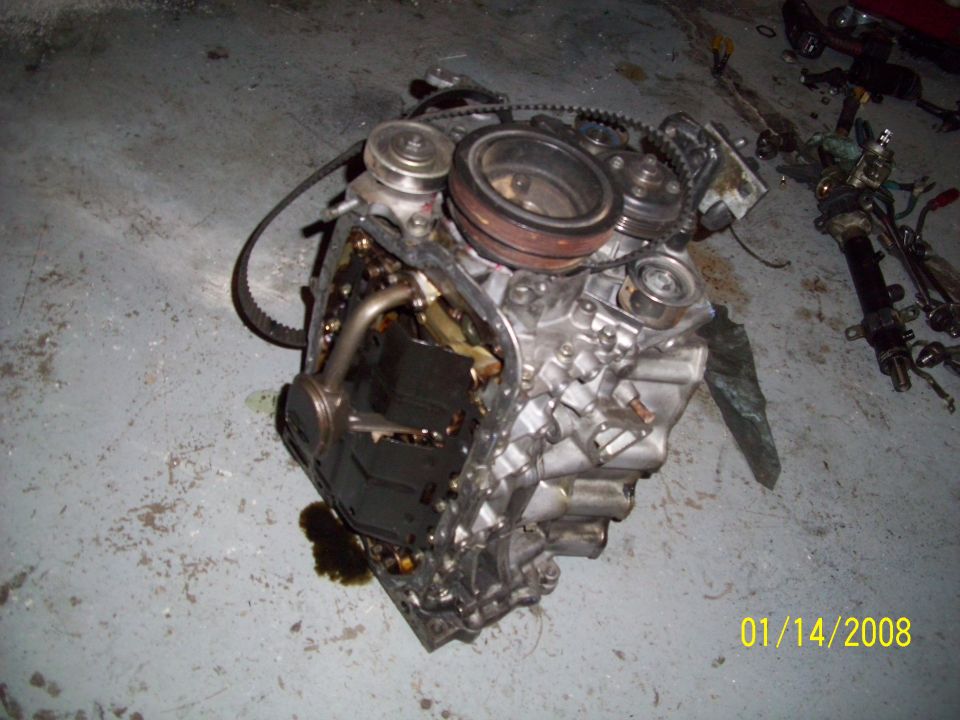 Engine block with oil pan removed, showing internal components and some oil leakage