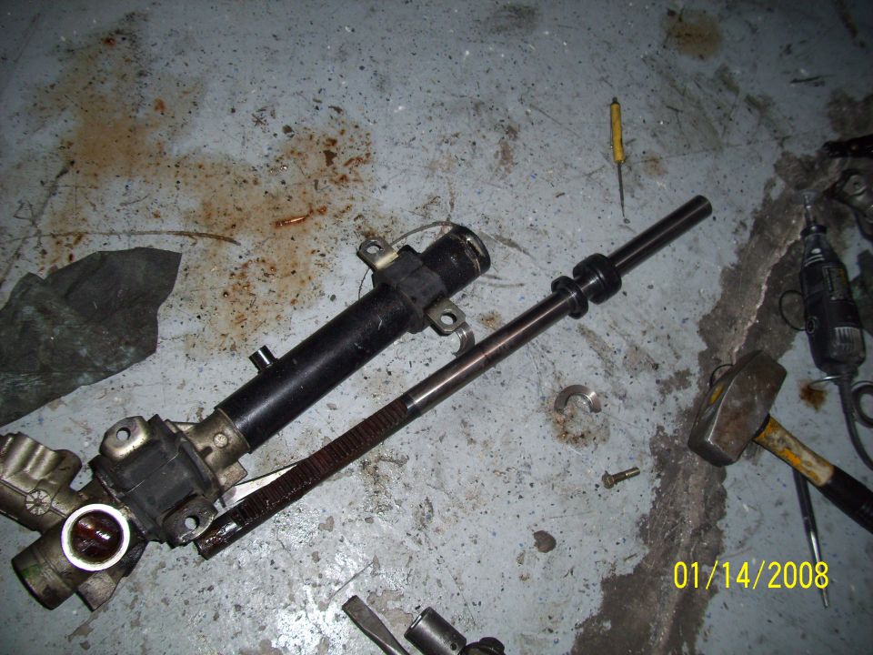 Steering rack and pinion assembly on concrete floor with tools