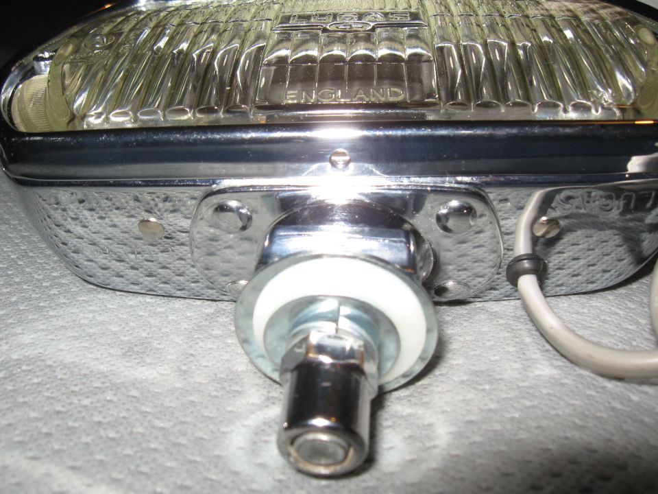 Chrome Lucas fog light with ribbed glass and "ENGLAND" text, mounted on a textured surface