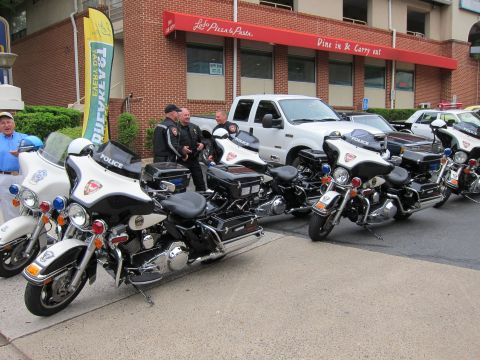 1991 Ford LTD Crown Victoria - White police motorcycles marked Police lined up with officers in front of a brick pizza restaurant building.