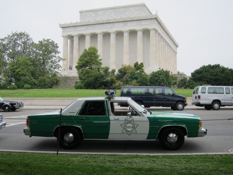 1991 Ford LTD Crown Victoria - green-and-white Ford Sheriff patrol sedan is shown in profile on the street in front of the Lincoln Memorial.