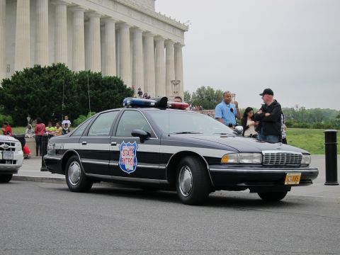 1991 Ford LTD Crown Victoria - black and white STATE PATROL Chevrolet Caprice cruiser with a shield emblem and roof light bar parked in front of the Lincoln Memorial colu…