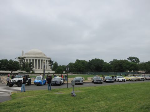 1991 Ford LTD Crown Victoria - row of classic police cars and a small police cart are parked near the domed Jefferson Memorial on an overcast day.