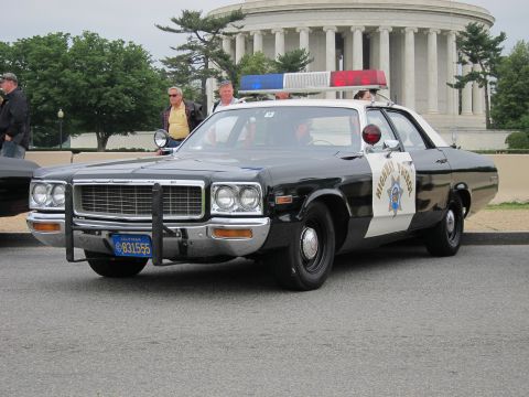 1991 Ford LTD Crown Victoria - black and white California Highway Patrol sedan with roof lights is parked in front of a columned domed memorial.