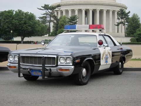 1991 Ford LTD Crown Victoria - black and white California Highway Patrol sedan with a roof light bar is parked in front of a columned domed memorial.