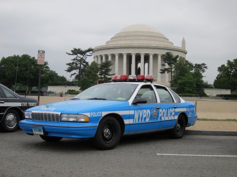 1991 Ford LTD Crown Victoria - light blue NYPD Chevrolet Caprice patrol car with roof lights is parked in front of the columned Jefferson Memorial.