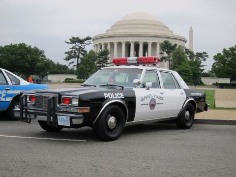 1991 Ford LTD Crown Victoria - black and white Chevrolet Caprice marked Jaffrey Police with roof lights is parked before the columned domed memorial.