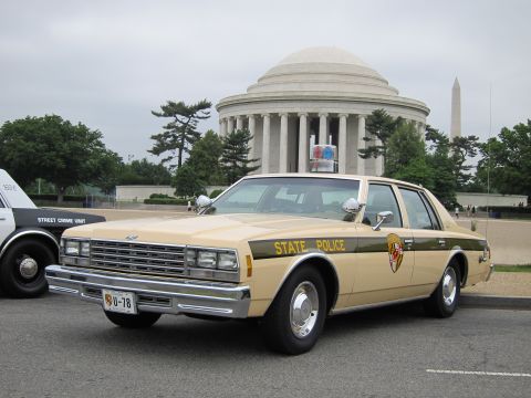 1991 Ford LTD Crown Victoria - vintage tan-over-black State Police sedan with a Maryland shield decal sits in front of the domed Jefferson Memorial.