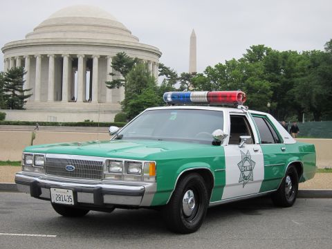 1991 Ford LTD Crown Victoria - green-and-white Ford sheriff cruiser with red and blue roof lights parked near the Jefferson Memorial and Washington Monument.