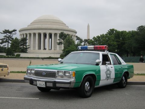1991 Ford LTD Crown Victoria - Front three-quarter of a green-and-white Ford sheriff cruiser parked on a road in front of the Jefferson Memorial.