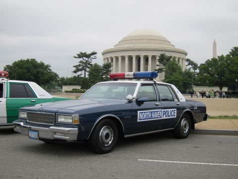 1991 Ford LTD Crown Victoria - dark blue Chevrolet Caprice marked North Haven Police with roof lightbar parked before the Jefferson Memorial.