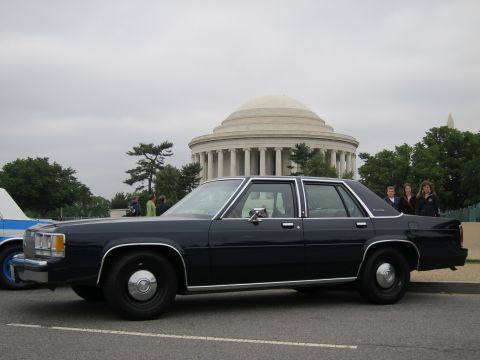 1991 Ford LTD Crown Victoria - Side profile of a black Ford LTD Crown Victoria sedan parked on a road in front of the Jefferson Memorial.