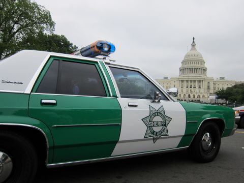1991 Ford LTD Crown Victoria - Close-up of a green-and-white sheriff cruiser's star door decal with the US Capitol dome rising behind it.