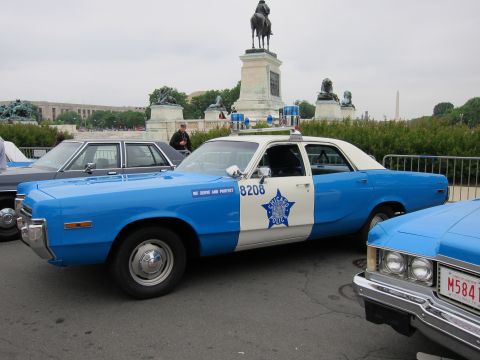 1991 Ford LTD Crown Victoria - blue-and-white Plymouth marked Chicago Police with star decal parked near an equestrian statue and the Washington Monument.