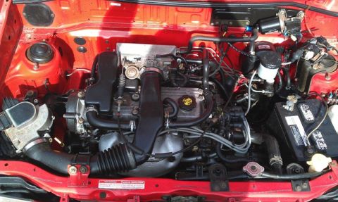 1991 Ford Festiva - The engine bay of a 1991 Ford Festiva is visible, with the engine, battery, and associated components clearly depicted.