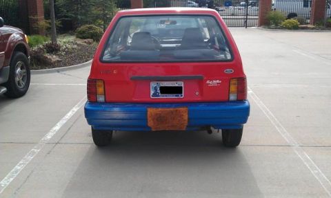 1991 Ford Festiva - Rear view of a red 1991 Ford Festiva, showing its distinctive blue bumper and Oklahoma license plate.