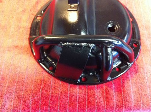 1987 Suzuki Samurai - A black differential cover with a welded protective bar is shown against a red textured background.
