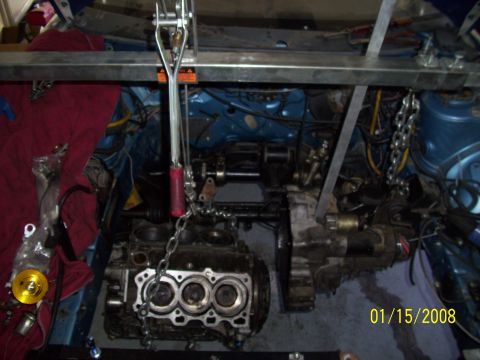 1995 Ford Probe - Engine assembly being hoisted out of a vehicle's engine bay.