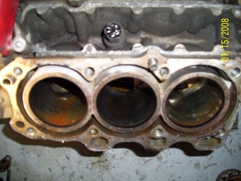 1995 Ford Probe - Close-up view of an engine block's cylinder bank, showing signs of internal wear and rust.