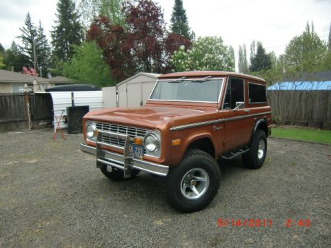 1973 Ford Bronco - This 1973 Ford Bronco is parked in a gravel driveway with a trailer and sheds in the background.