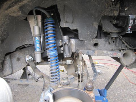 2008 Jeep Wrangler - Close-up view of modified front suspension components on a Jeep Wrangler, including aftermarket shocks and sway bar.