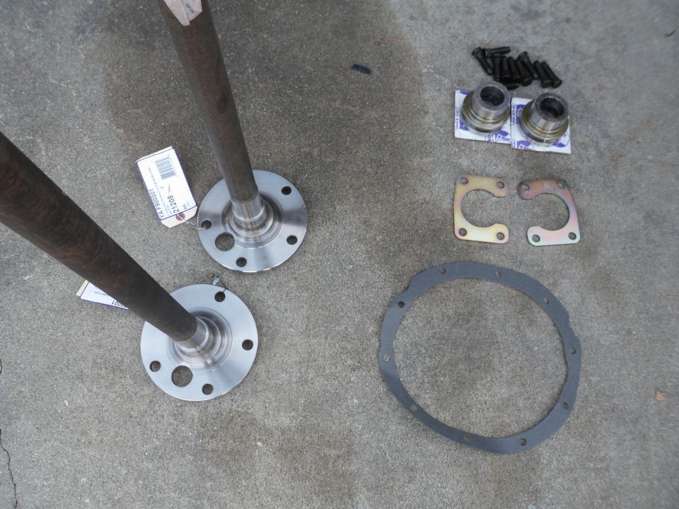 Axle shafts and differential parts laid out on concrete
