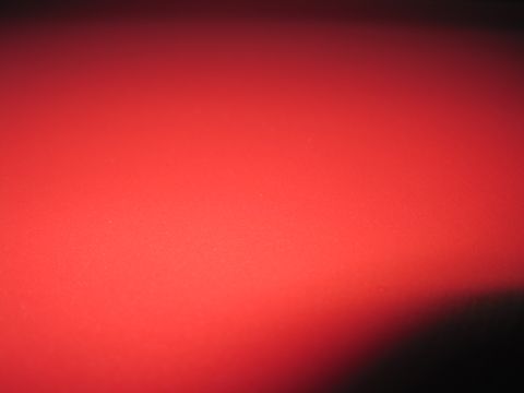 1979 Ford Bronco - A close-up of a red surface with a watermark at the bottom right corner.