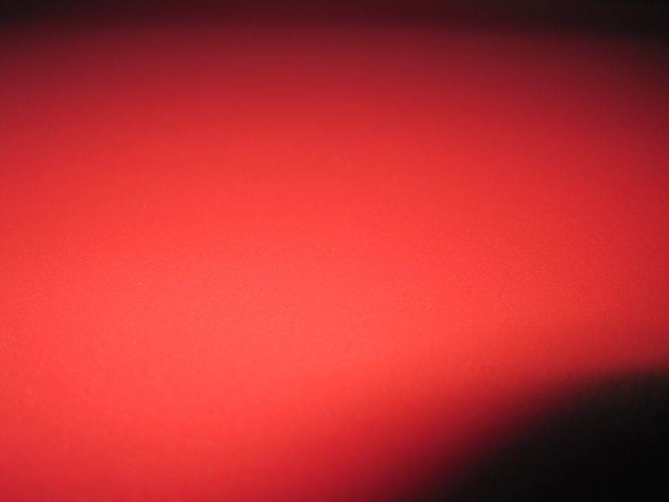 Red surface with a dark shadow on the right and text at the bottom right
