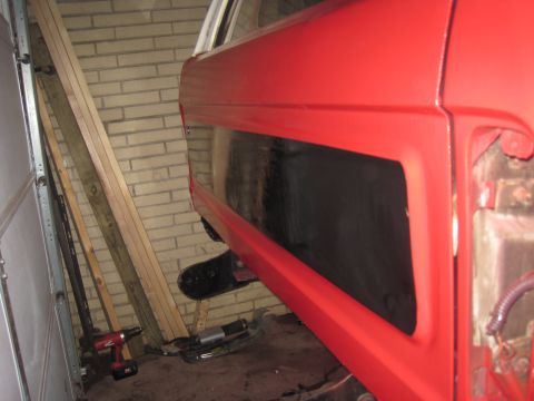 1979 Ford Bronco - Side view of a red 1979 Ford Bronco's rear quarter panel and window.