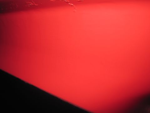 1979 Ford Bronco - A close-up of a red car panel shows a dark shadow on the left side and a watermark at the bottom right.